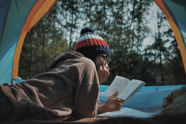 femme lisant dans une tente