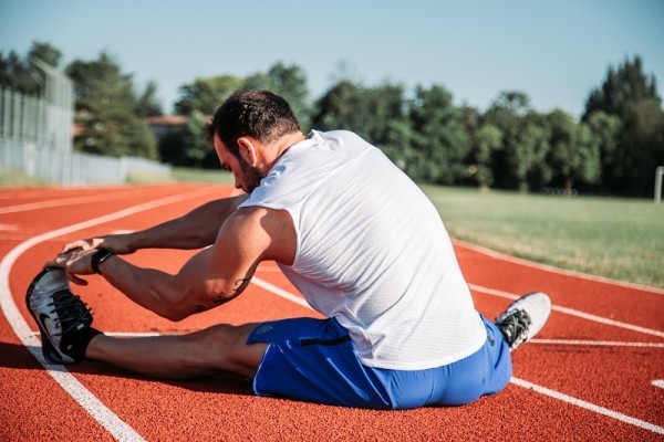 coureur faisant des étirements